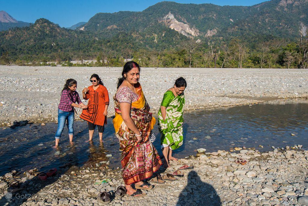 Senhoras indianas cruzam um riacho do rio Jayanti, Bengala Ocidental, Índia