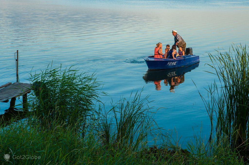 Barqueiro e passageiros no Lago Nero, Rostov Veliky, Rússia