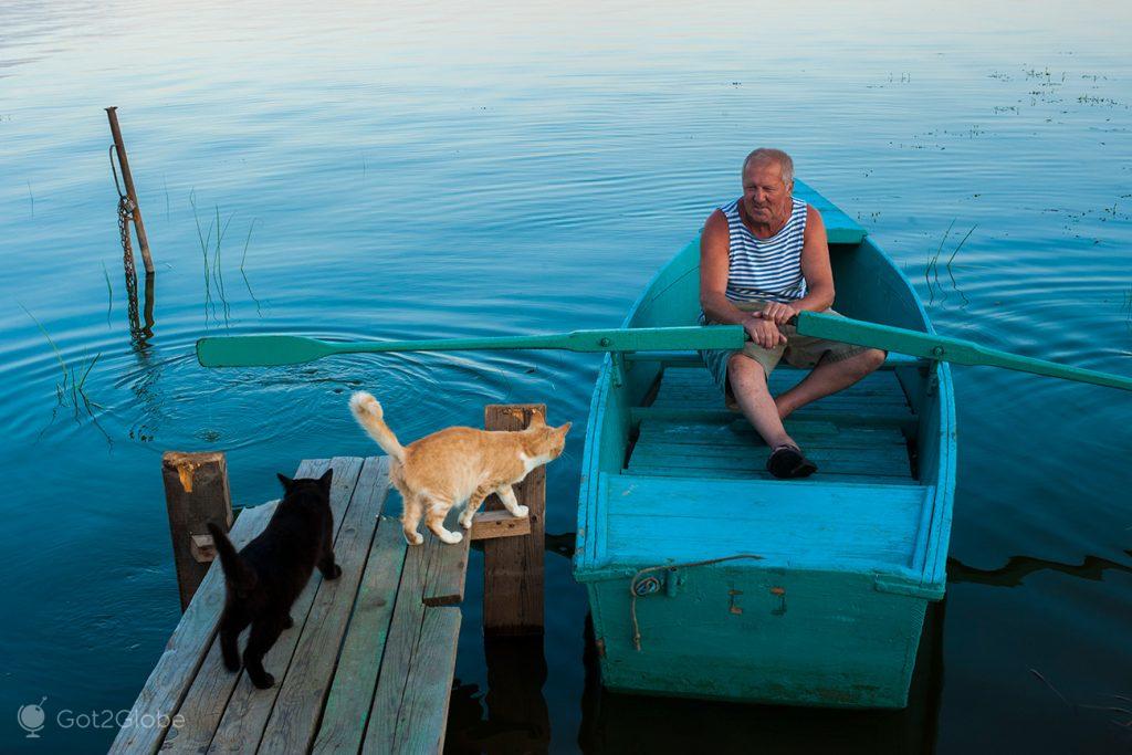 Barqueiro e gatos, no lago Nero, Rostov Veliky, Rússia