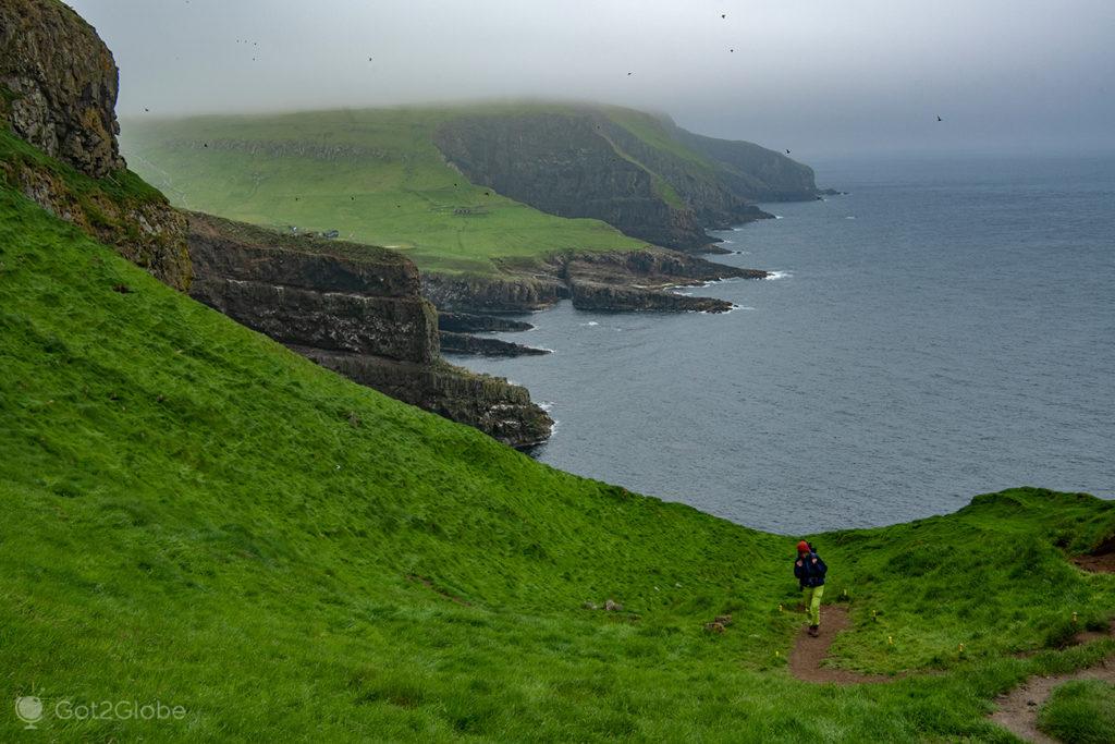 Caminhante num trilho de Mykinesholmur, Mykines, Ilhas Faroé