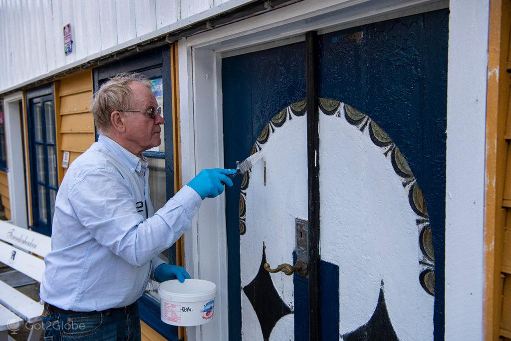 Morador pinta uma porta tradicional, Sokndalstrand, Rogaland, Noruega